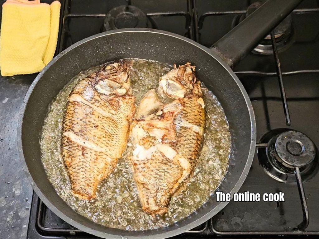 turn fried fish to cook evenly on both sides